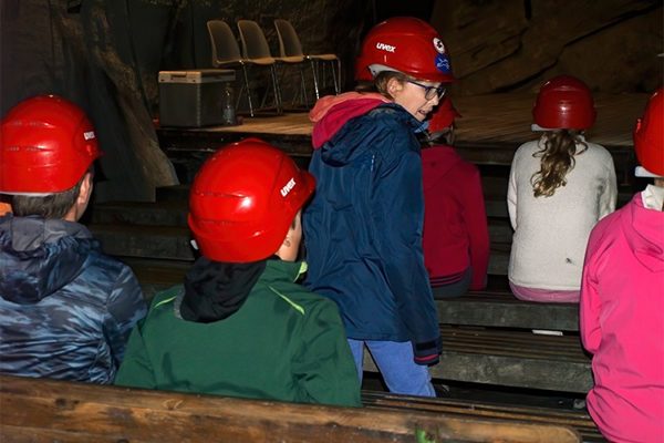 Die Jugendlichen mit roten Helmen im Bergwerk (Stollen)